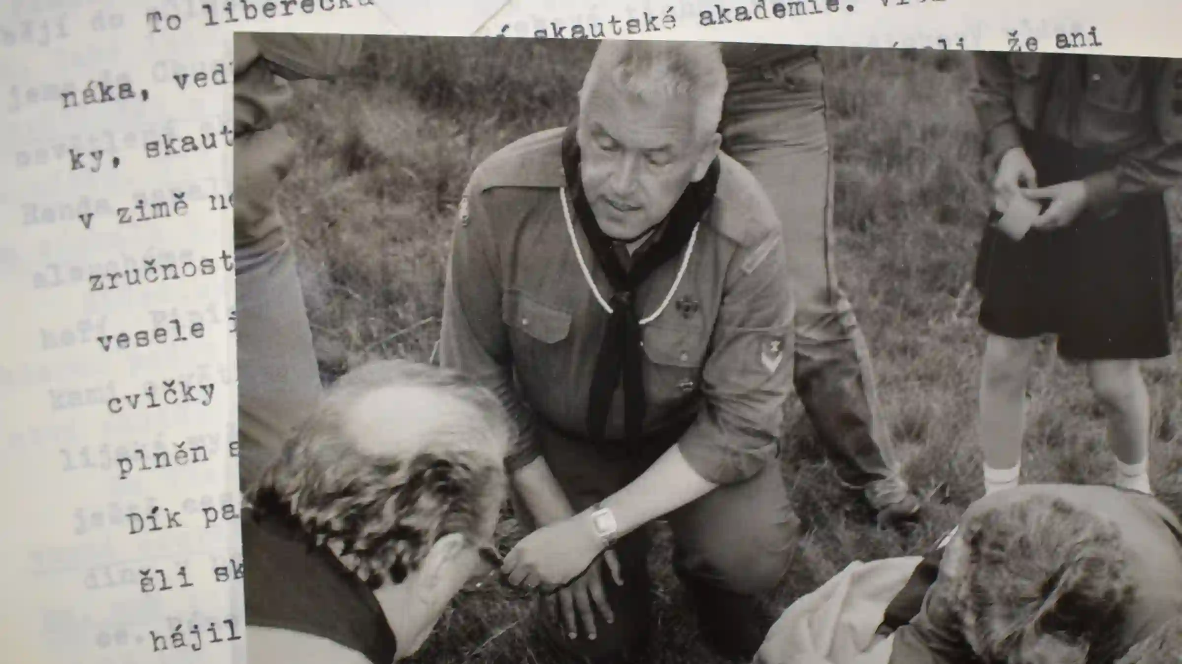 Archivní fotografie skautského vedoucího při praktickém výcviku s dětmi v přírodě.
